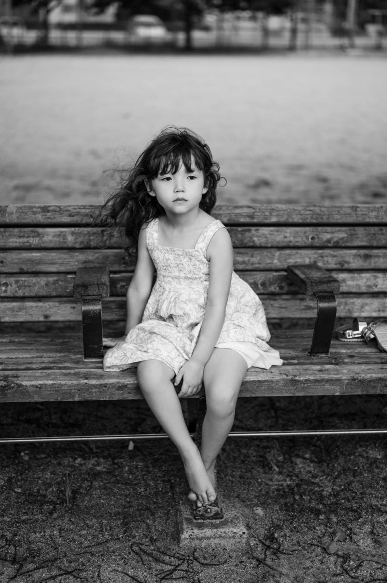 black and white photo of little girl on a bench, lifestyle photo