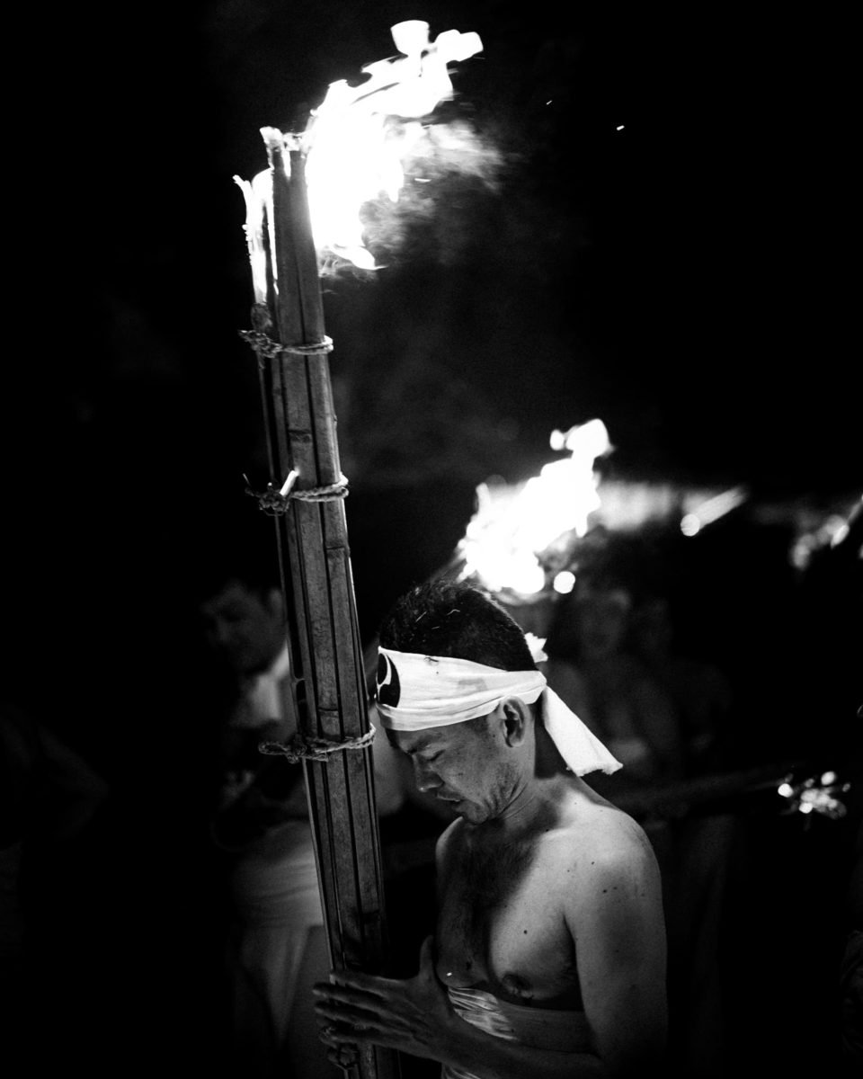 black and white sample photo of a man praying with a torch.