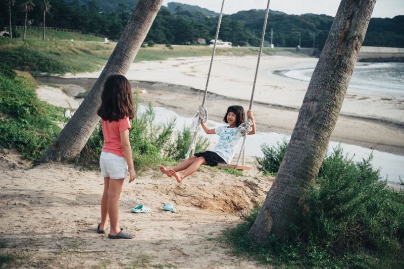 girls playing on swing.