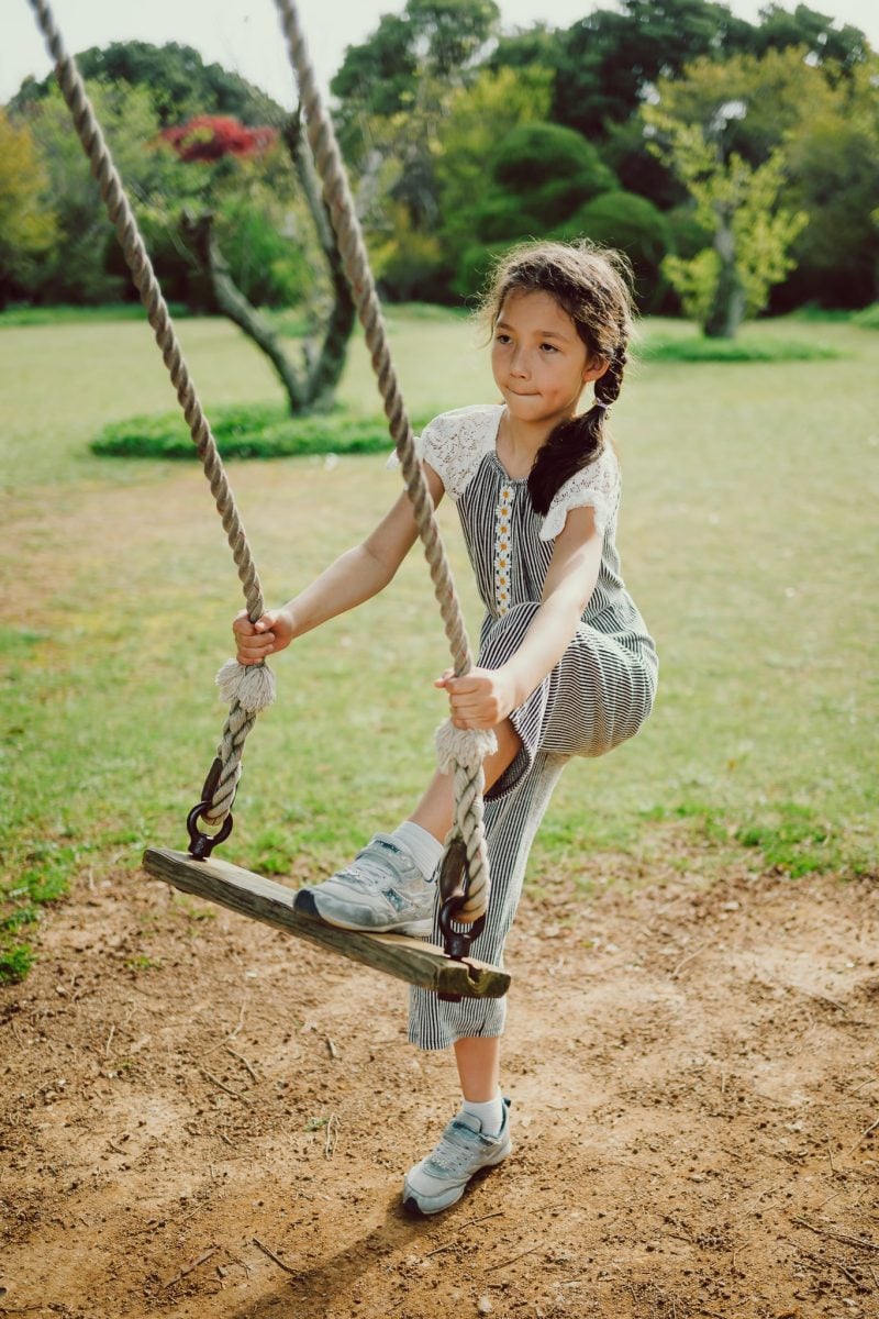 Girl with one foot on a swing