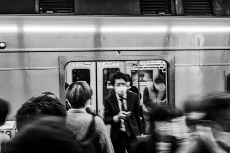 Slow Shutter black and white shot of crowd exiting train in Japan.