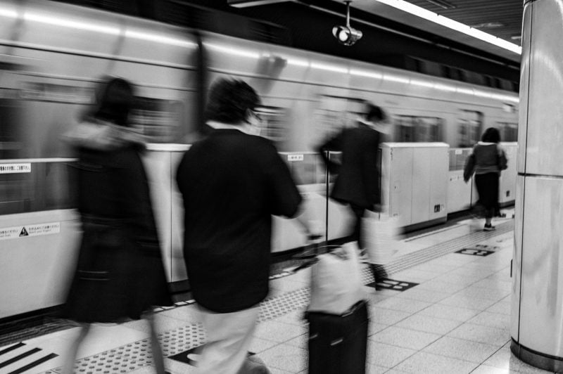 Slow Shutter black and white shot of crowd exiting train in Japan.