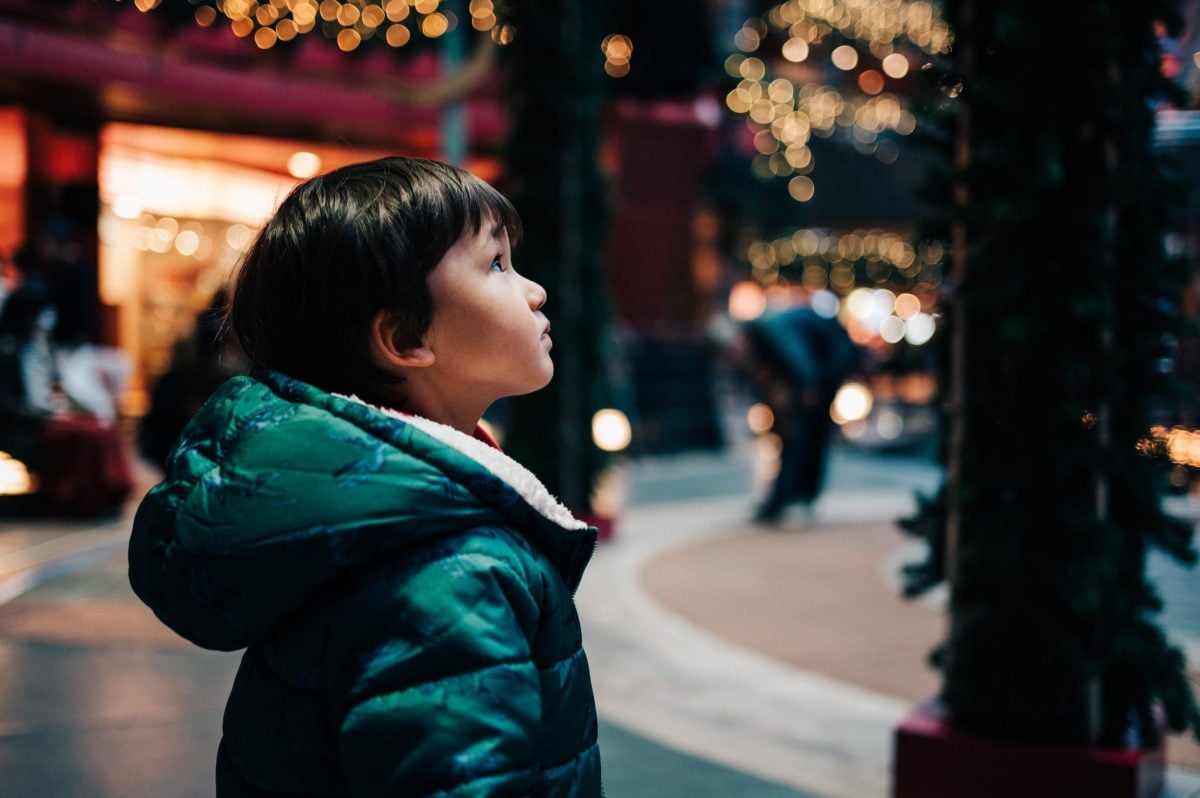 boy looking up at some lights.