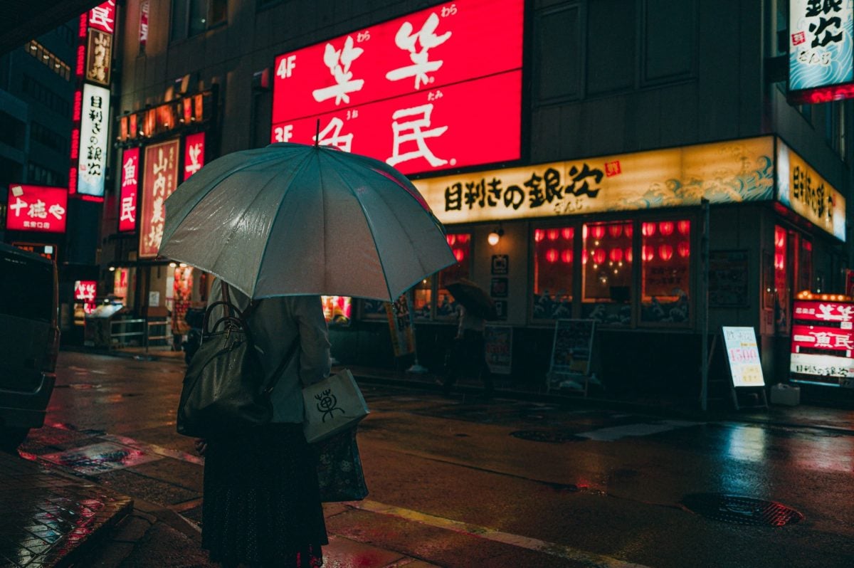 Hakata Japan Street Photo of Woman holding umbrella in the rain.