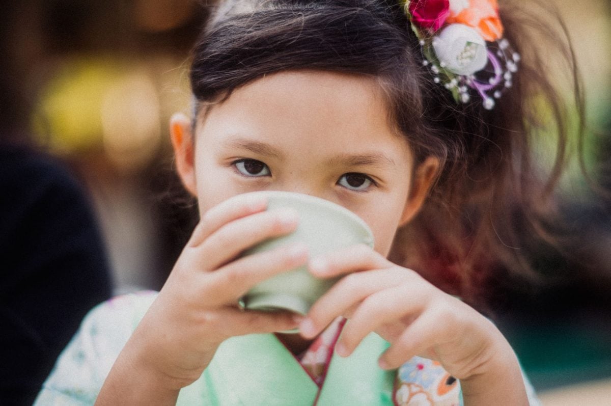 Portrait of little girl drinking tea