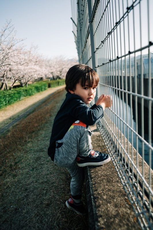 kid climbing fence. 